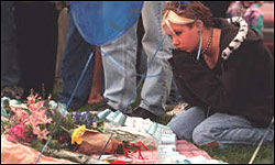 A girl kneels at a memorial in Clement Park