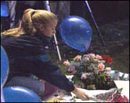 A girl adds more flowers to this Columbine memorial site