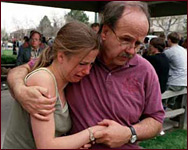 A father leads his upset daughter away from the horror