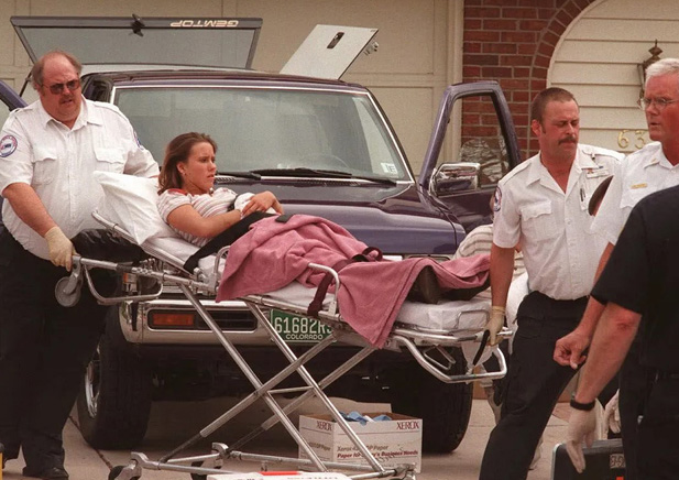 Paramedics move the wounded on gurney at Columbine